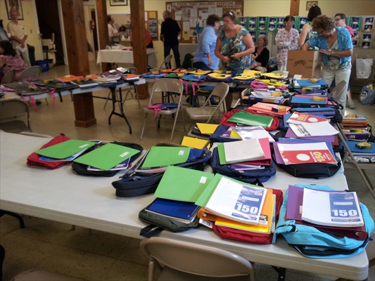 Parishioners assemble backpacks for local school children